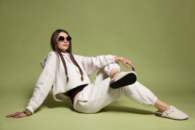 Photo of Fashionable portrait of beautiful woman in stylish outfit on green background