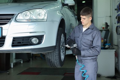 Photo of Professional mechanic changing tire at car service