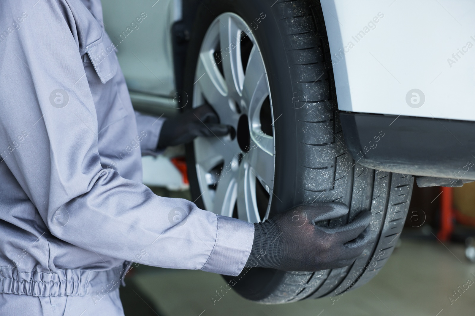 Mechanic changing tire at car service, closeup Photo of Mechanic changing tire at car service, closeup