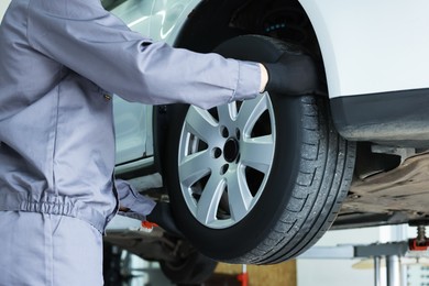 Photo of Mechanic changing tire at car service, closeup