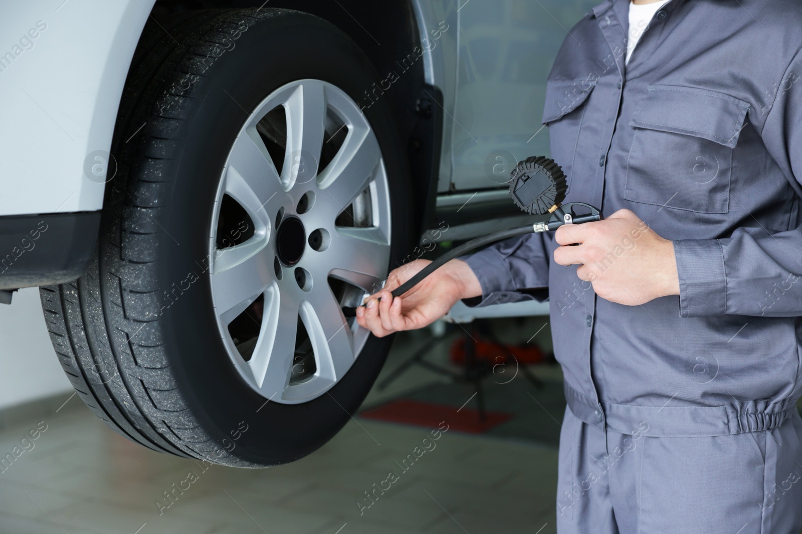 Mechanic inflating new tire at car service, closeup Photo of Mechanic inflating new tire at car service, closeup