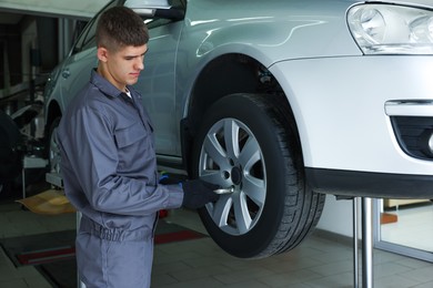 Photo of Professional mechanic changing tire at car service