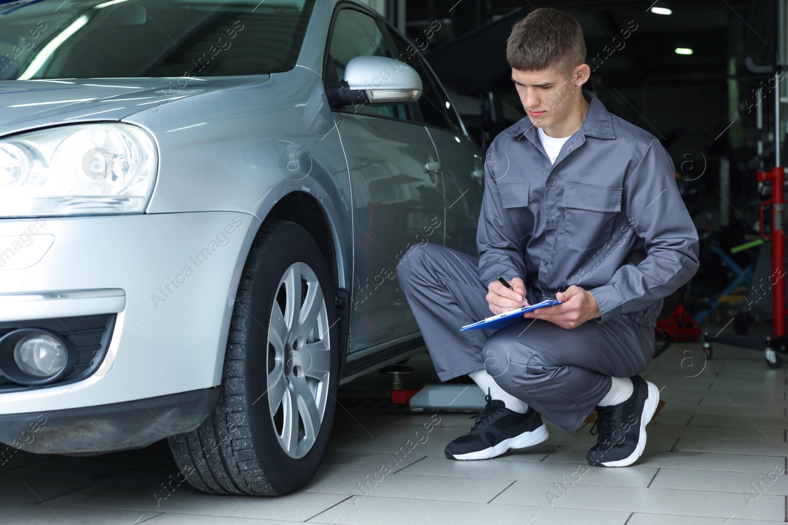 Mechanic checking tire after change at car service Photo of Mechanic checking tire after change at car service