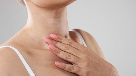 Photo of Woman with moles on her body against light background, closeup. Space for text
