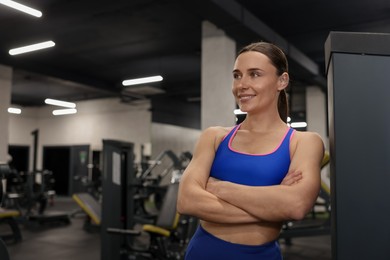 Photo of Portrait of professional personal trainer in gym. Space for text