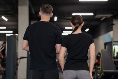 Photo of Personal trainers in sport center, back view