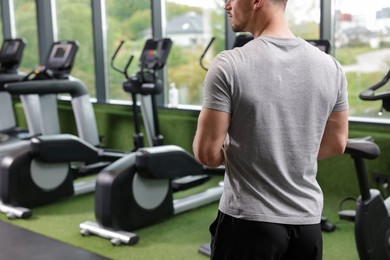 Photo of Personal trainer in sport center, back view