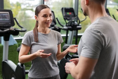 Photo of Professional personal trainers talking in sport center