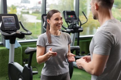 Photo of Professional personal trainers talking in sport center