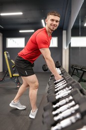 Photo of Professional personal trainer with dumbbells in gym