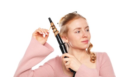 Photo of Woman curling her hair on white background