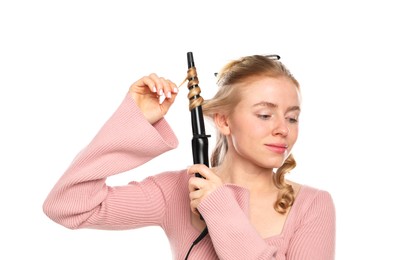 Photo of Woman curling her hair on white background