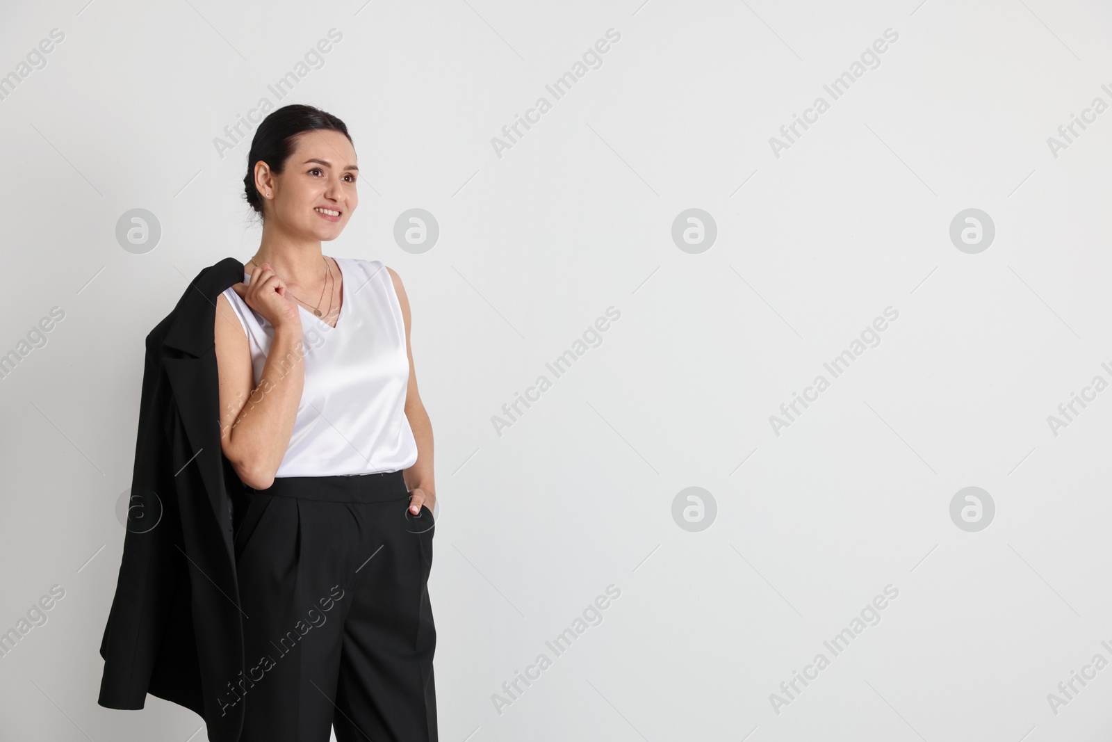 Confident business woman in suit on light background. Space for text Photo of Confident business woman in suit on light background. Space for text