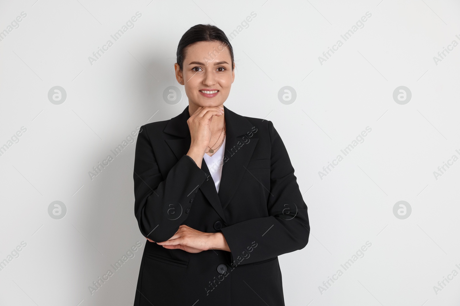 Confident business woman in suit on light background Photo of Confident business woman in suit on light background