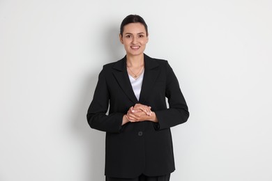 Photo of Confident business woman in suit on light background