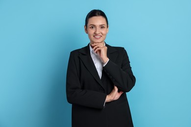 Photo of Confident business woman in suit on light blue background