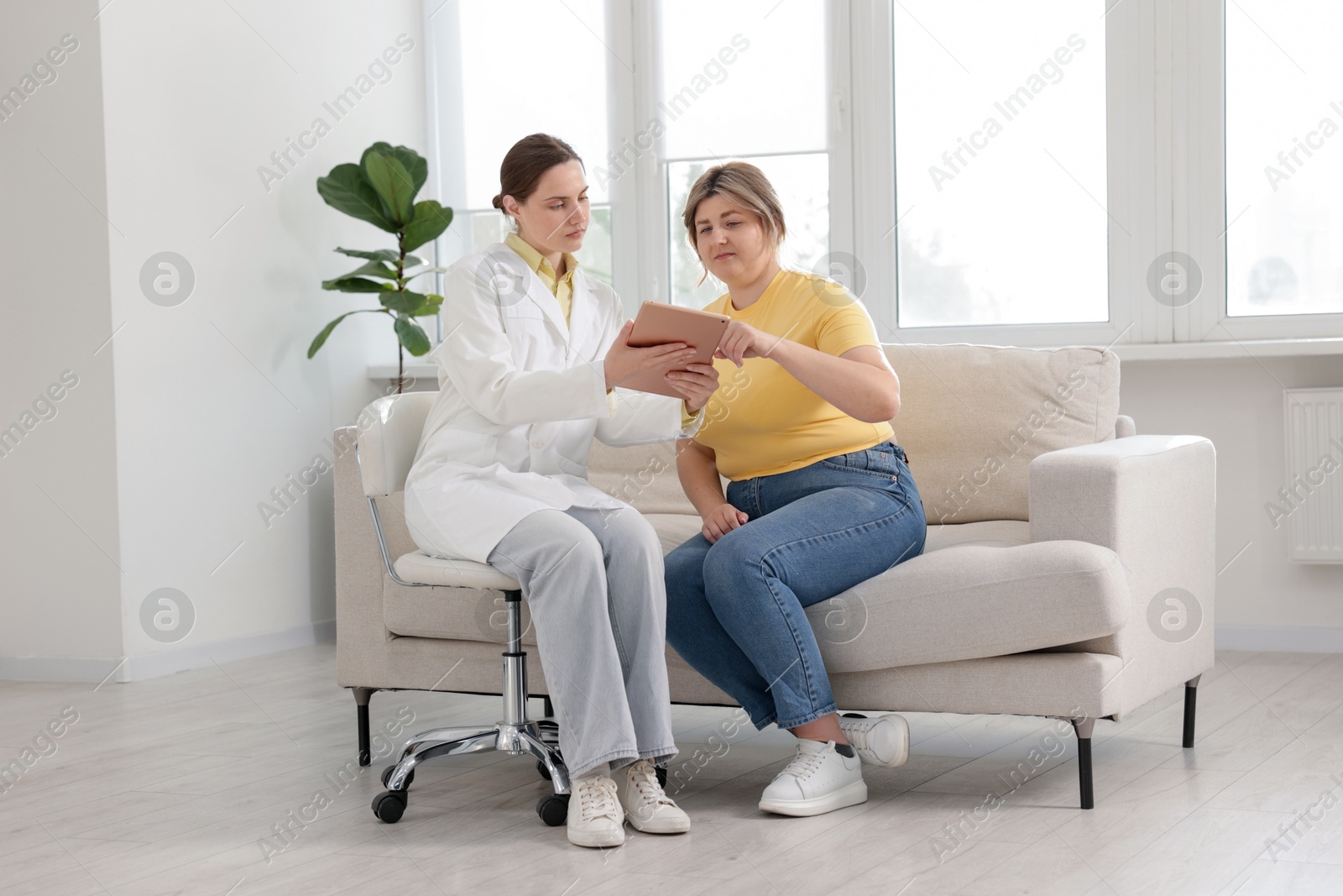 Weight loss. Nutritionist consulting overweight woman in clinic Photo of Weight loss. Nutritionist consulting overweight woman in clinic
