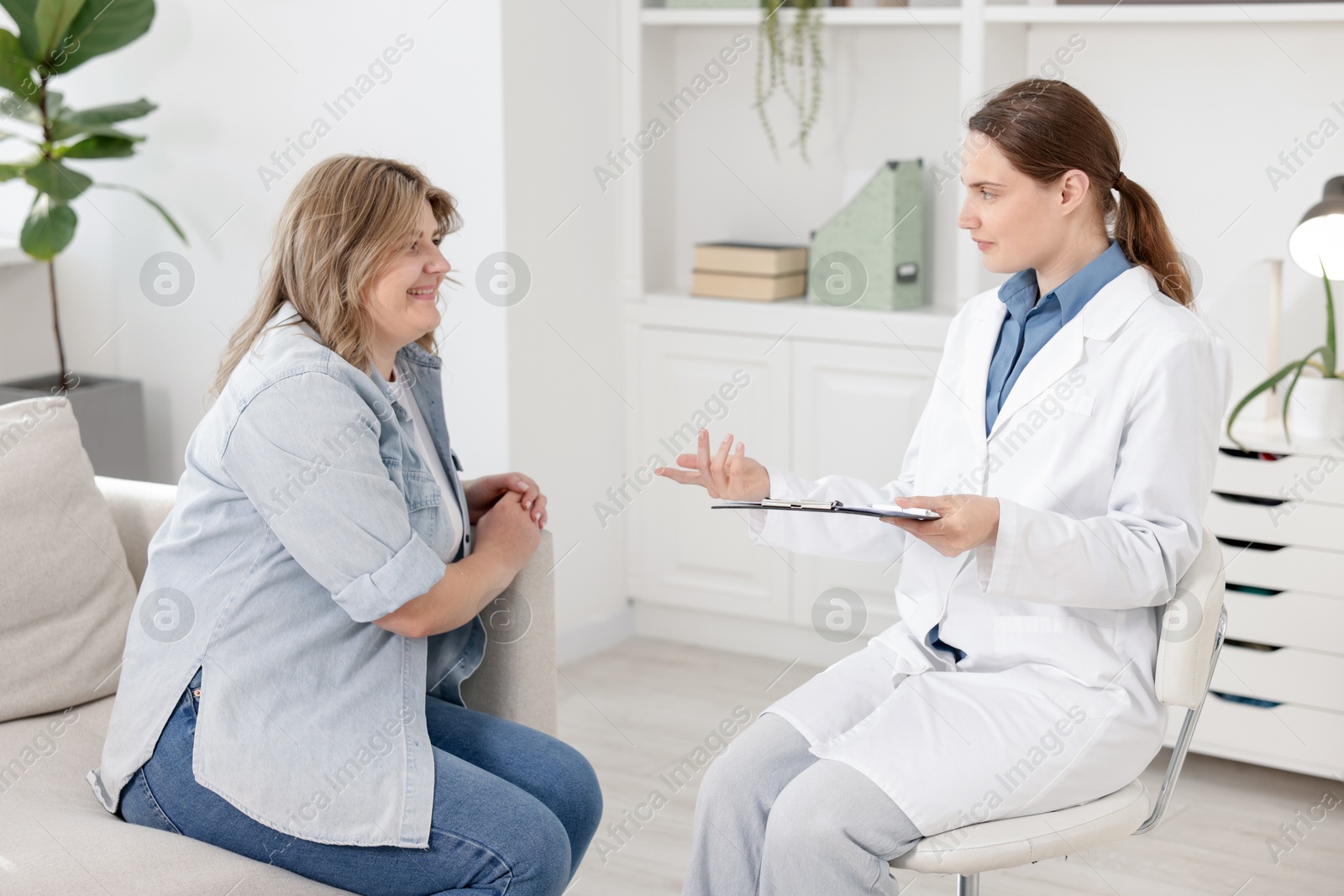 Weight loss. Nutritionist consulting overweight woman in clinic Photo of Weight loss. Nutritionist consulting overweight woman in clinic