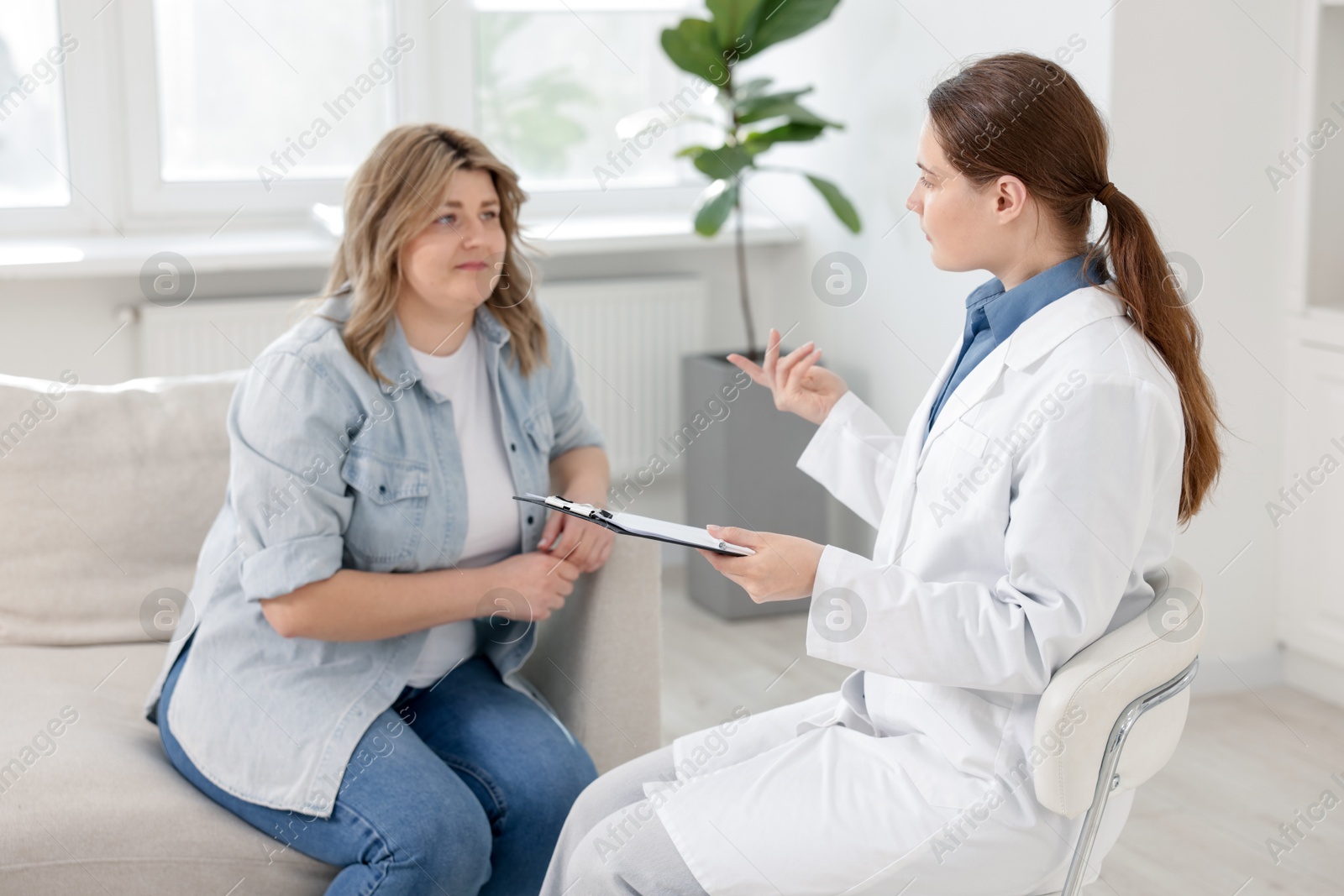 Weight loss. Nutritionist consulting overweight woman in clinic Photo of Weight loss. Nutritionist consulting overweight woman in clinic