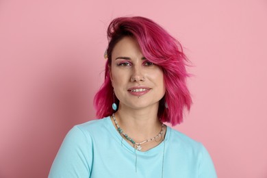 Photo of Beautiful woman with bright dyed hair on pink background