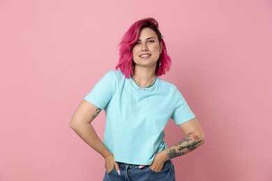 Photo of Beautiful woman with bright dyed hair on pink background