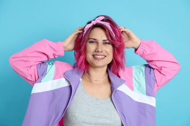 Photo of Beautiful woman with pink dyed hair on light blue background