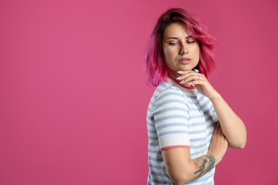 Photo of Beautiful woman with bright dyed hair on pink background, space for text