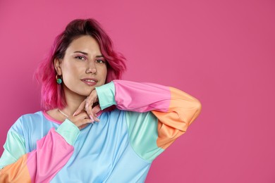 Photo of Beautiful woman with bright dyed hair on pink background, space for text