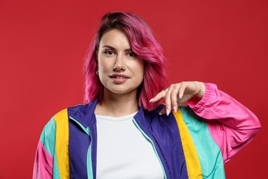 Photo of Beautiful woman with pink dyed hair on red background