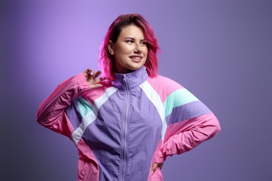Photo of Beautiful woman with pink dyed hair on violet gradient background