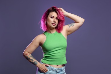 Photo of Beautiful woman with pink dyed hair on violet background