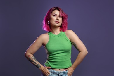 Photo of Beautiful woman with pink dyed hair on violet background