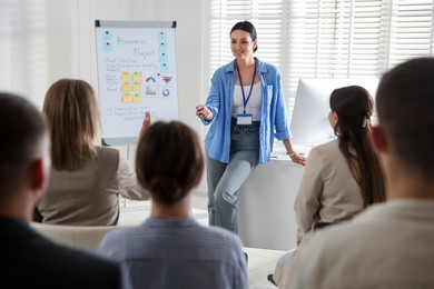 Photo of Woman giving public speech in front of audience indoors