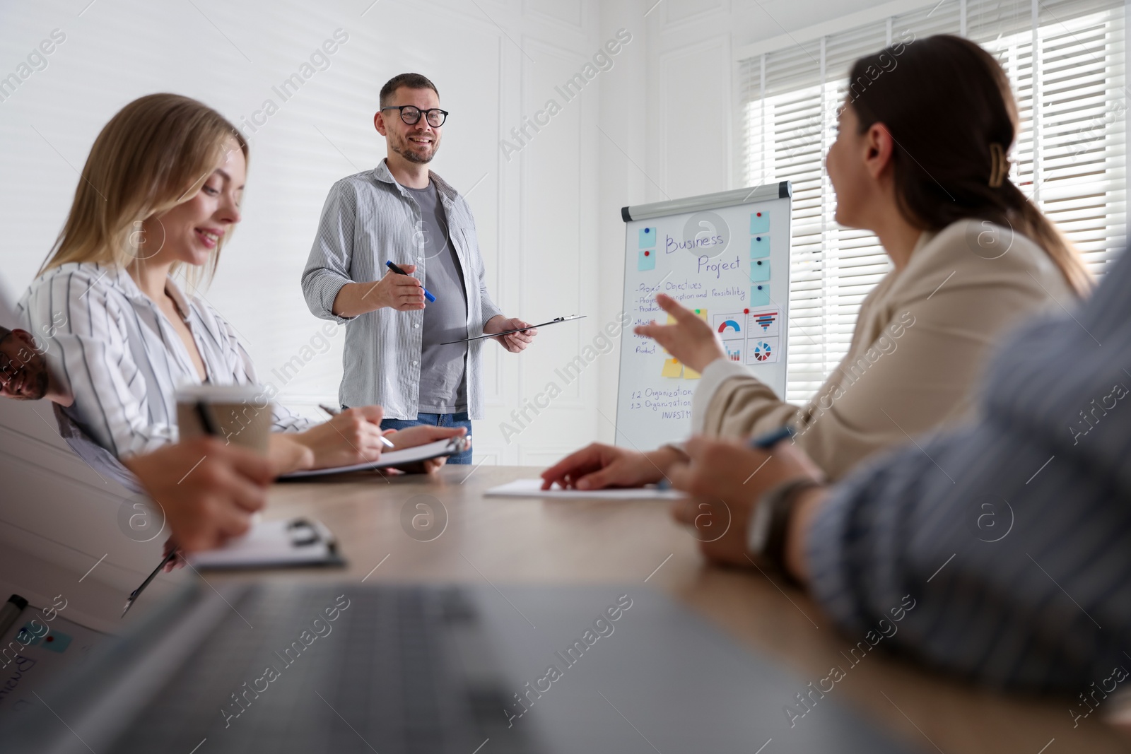 Man giving public speech in front of audience indoors Photo of Man giving public speech in front of audience indoors