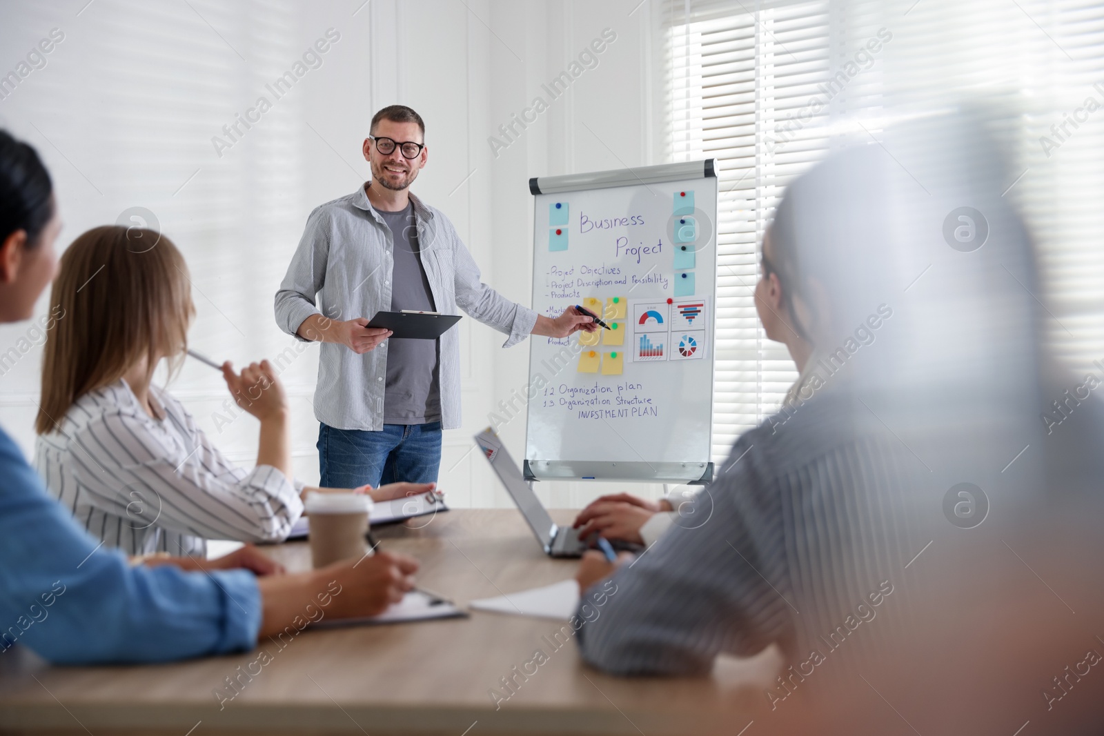 Man giving public speech in front of audience indoors Photo of Man giving public speech in front of audience indoors
