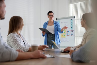 Photo of Woman giving public speech in front of audience indoors