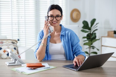 Photo of Travel agent working at wooden table in office