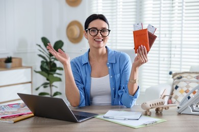 Photo of Travel agent with passports and tickets at wooden table in office