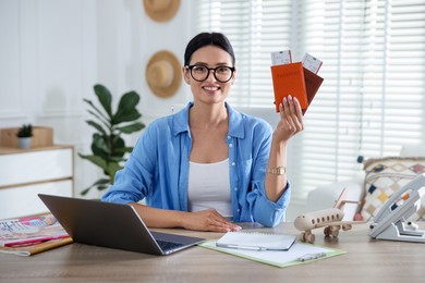 Photo of Travel agent with passports and tickets at wooden table in office