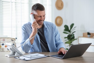 Photo of Travel agent working at wooden table in office