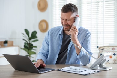Photo of Travel agent working at wooden table in office