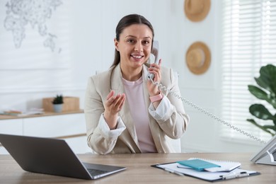 Photo of Travel agent working at wooden table in office
