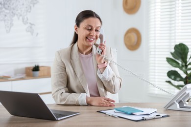 Photo of Travel agent working at wooden table in office