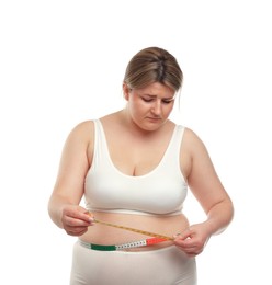 Photo of Weight loss. Plus size woman measuring waist with tape on white background
