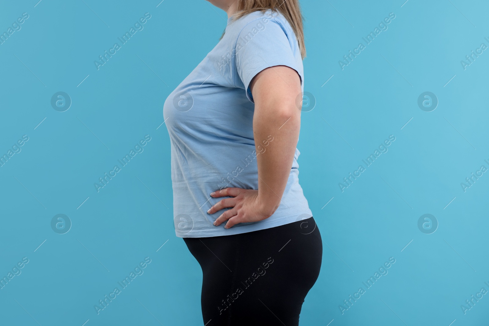 Weight loss. Plus size woman on light blue background, closeup Photo of Weight loss. Plus size woman on light blue background, closeup