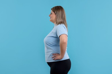 Photo of Weight loss. Plus size woman on light blue background