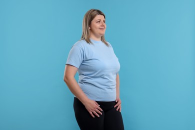 Photo of Weight loss. Plus size woman on light blue background