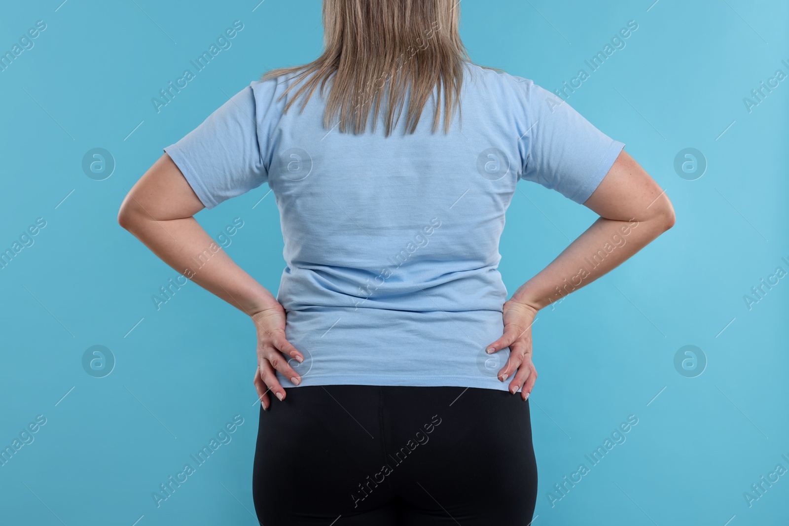 Weight loss. Plus size woman on light blue background, closeup Photo of Weight loss. Plus size woman on light blue background, closeup