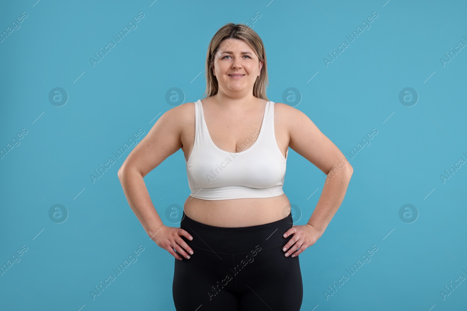 Weight loss. Plus size woman on light blue background Photo of Weight loss. Plus size woman on light blue background