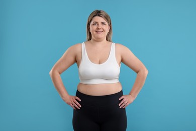 Photo of Weight loss. Plus size woman on light blue background